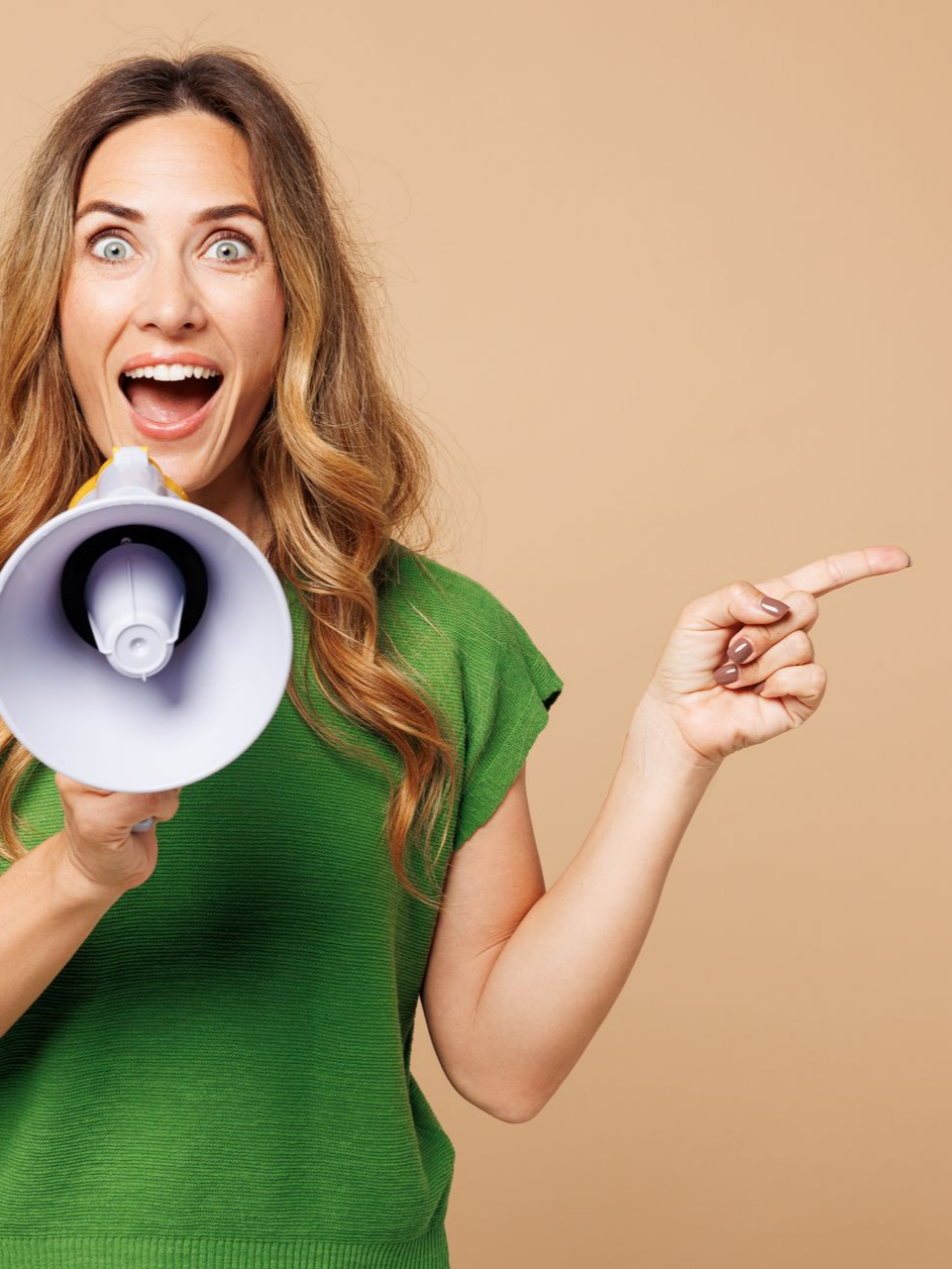 Une femme en haut vert crie dans un mégaphone, pointant vers la droite avec une expression excitée.