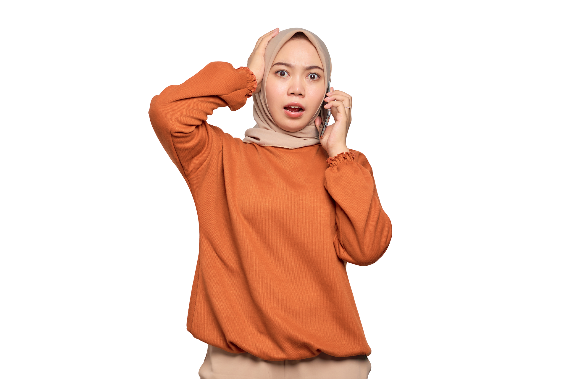Une femme portant un hijab, l'air surpris et tenant sa tête tout en parlant au téléphone.