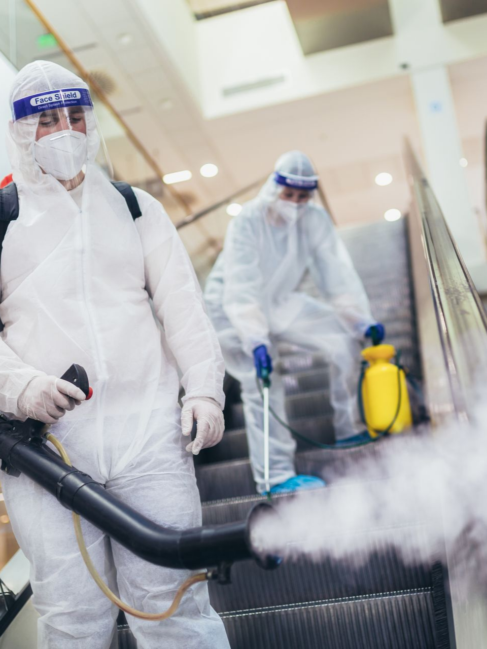 Des hommes qui désinfectent un escalator