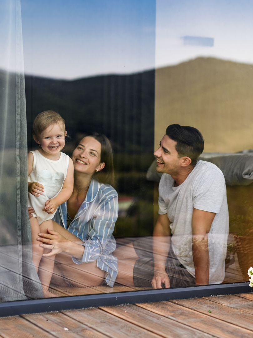 Une famille derrière une baie vitrée