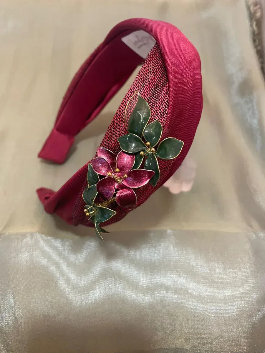Diadema burdeos con adornos florales.