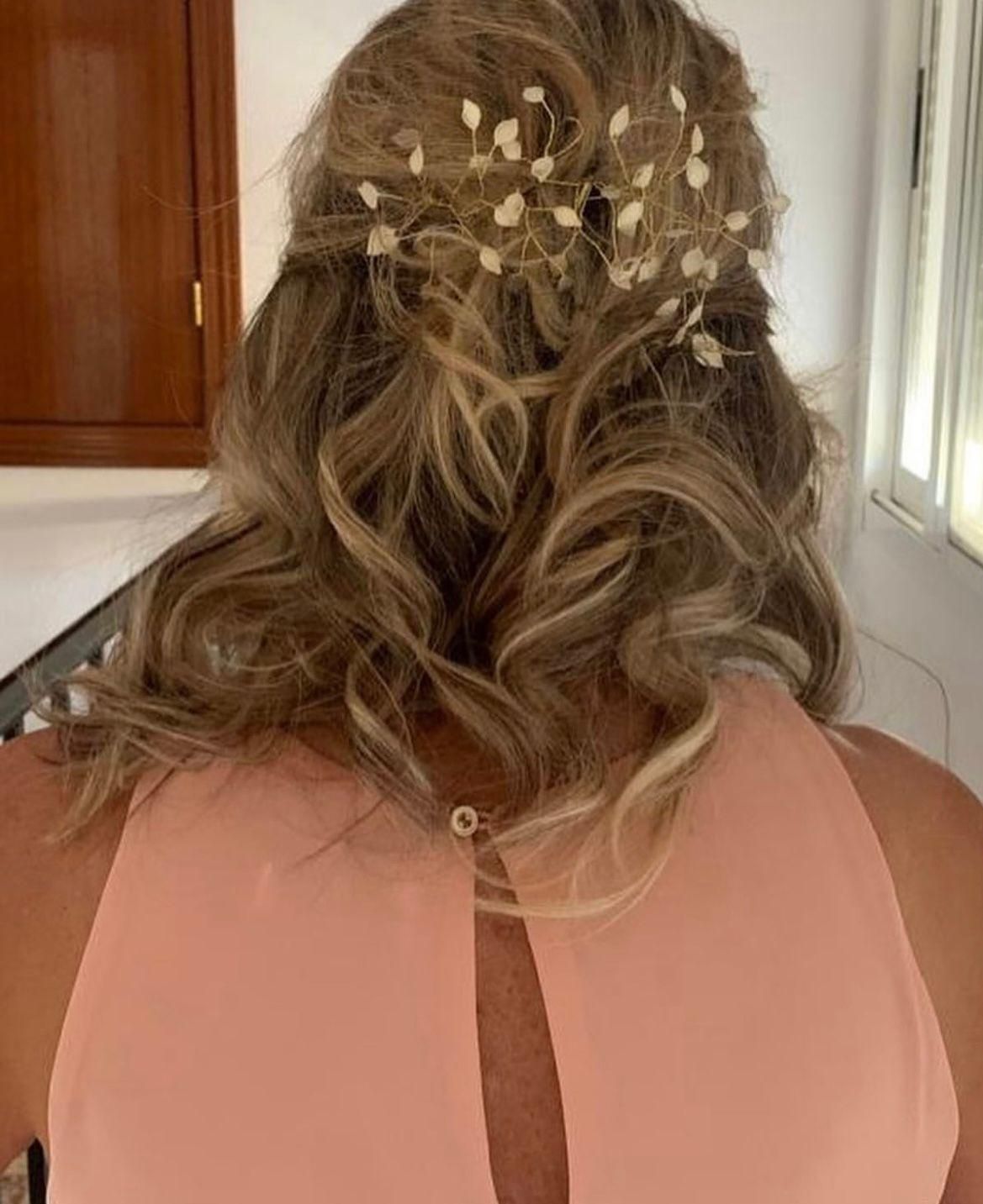 Peinado rubio ondulado con tocado floral y vestido color melocotón. Interior.