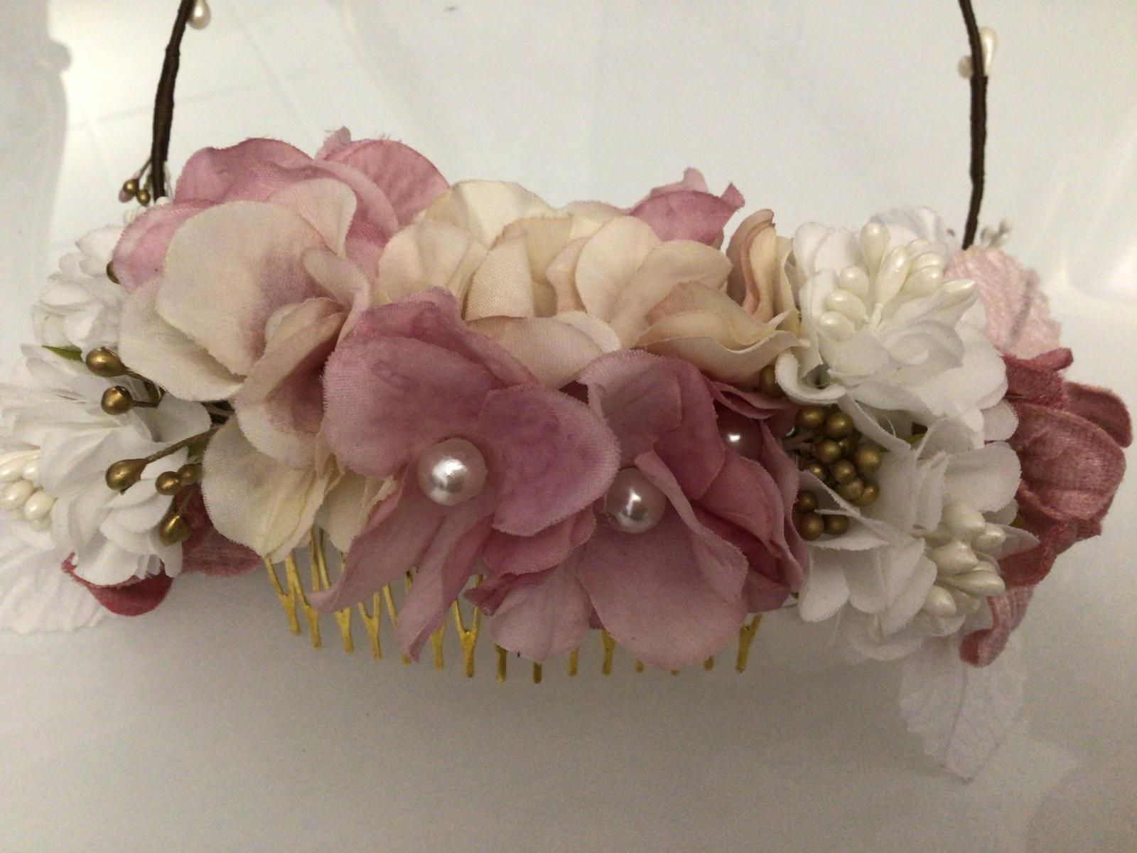 Peineta floral con flores rosas, crema y blancas, acentuada con perlas y detalles dorados.