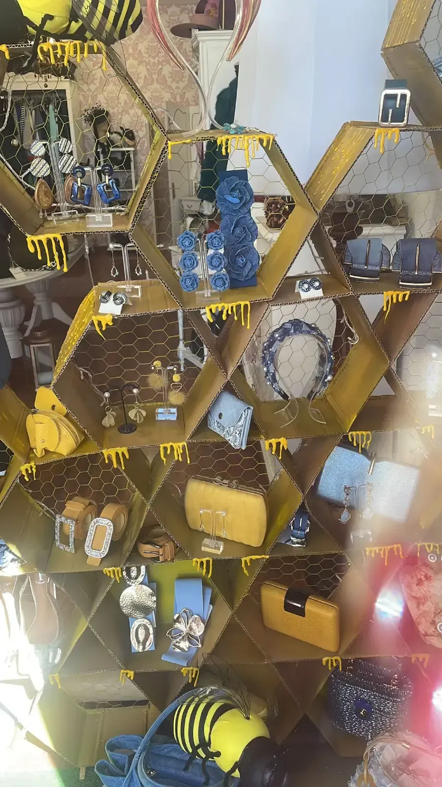 Vitrina en forma de panal con productos relacionados con la miel, entre los que se incluyen ositos azules.