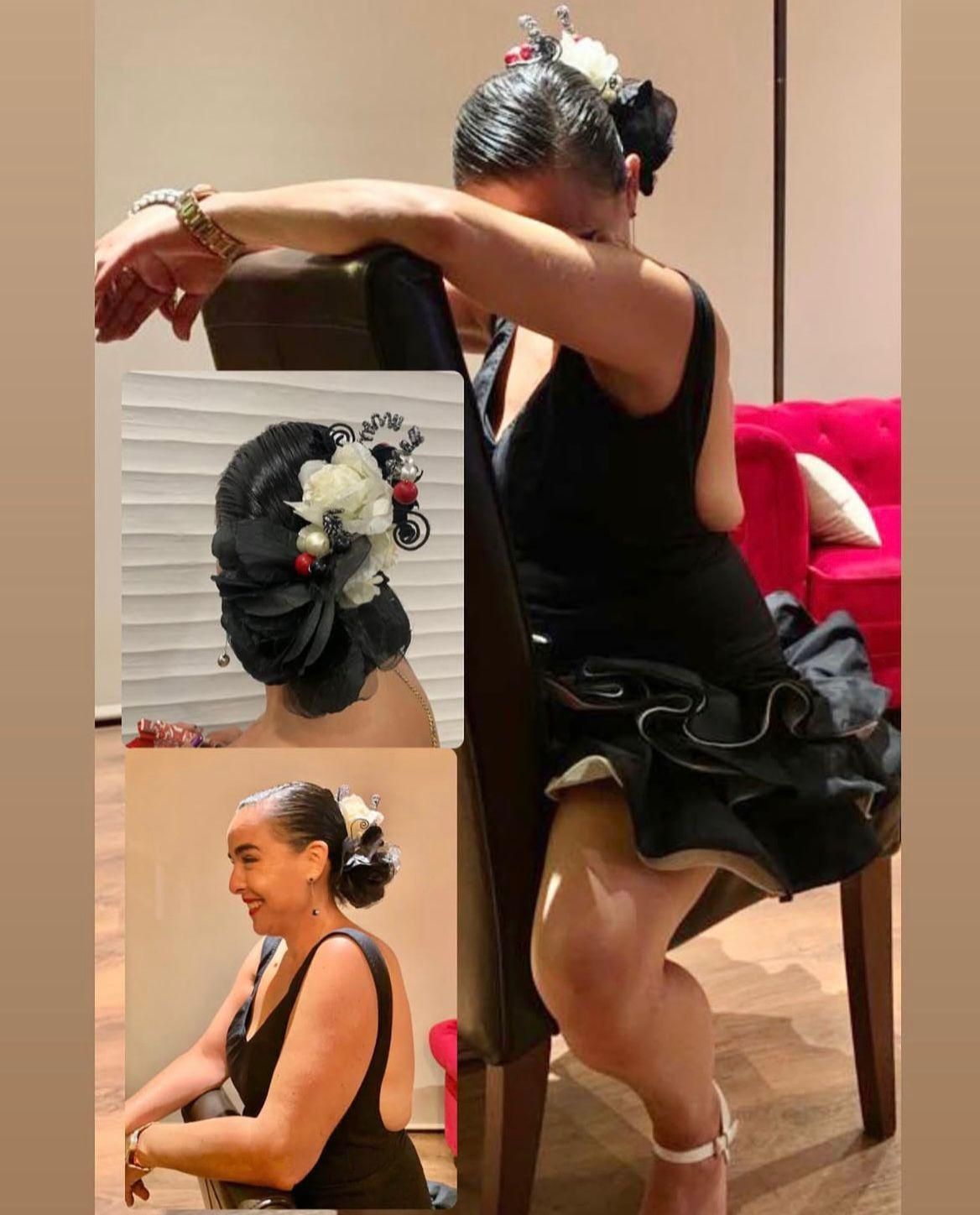 Mujer con vestido negro, peinado flamenco, sentada en una silla, con los brazos apoyados en el respaldo de la silla.