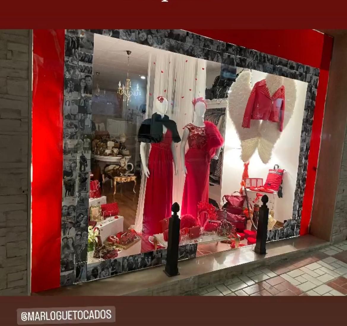 Escaparate de tienda con vestidos rojos, alas de ángel y detalles en rojo.