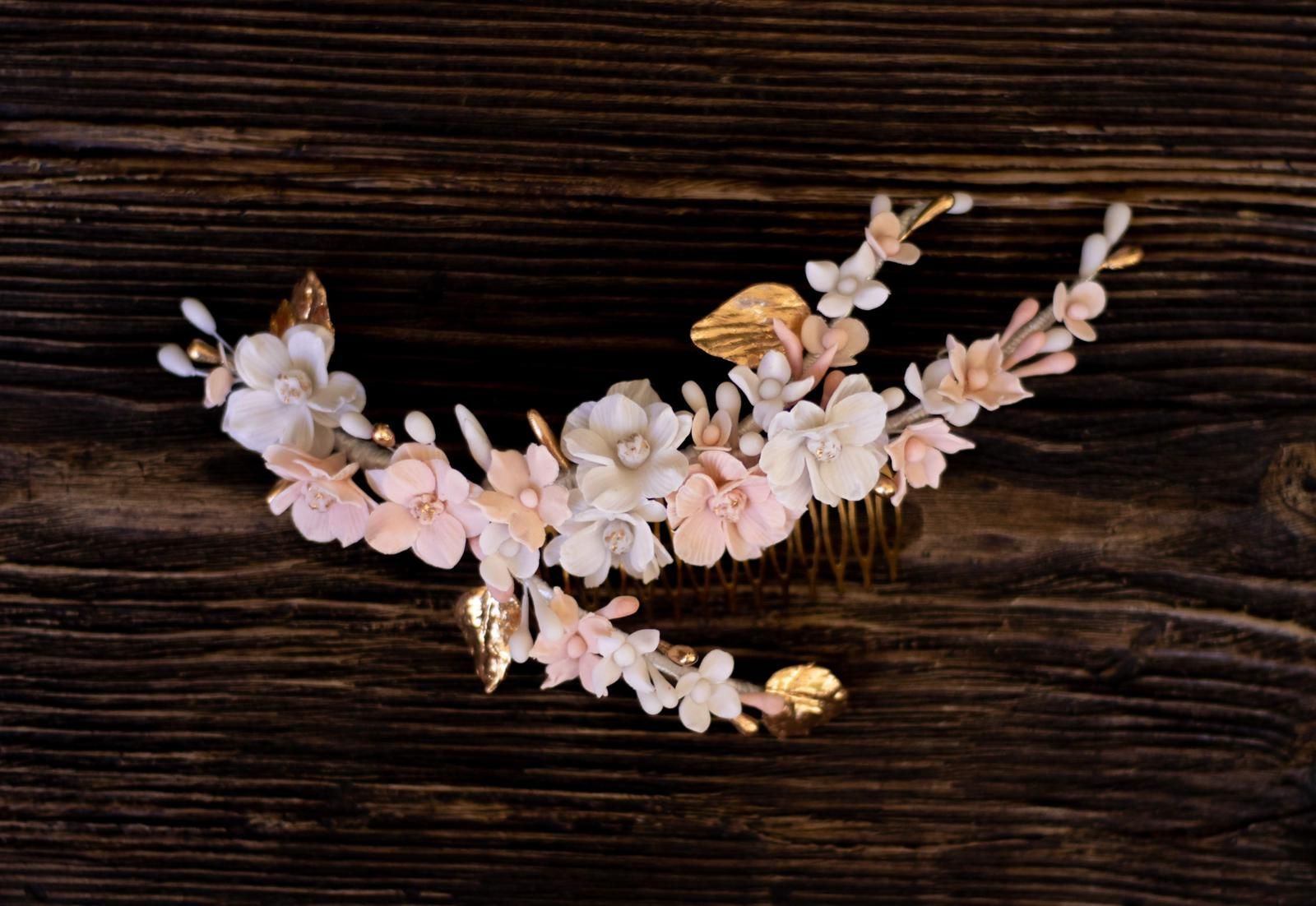 Peineta floral con flores rosas y blancas y hojas doradas.