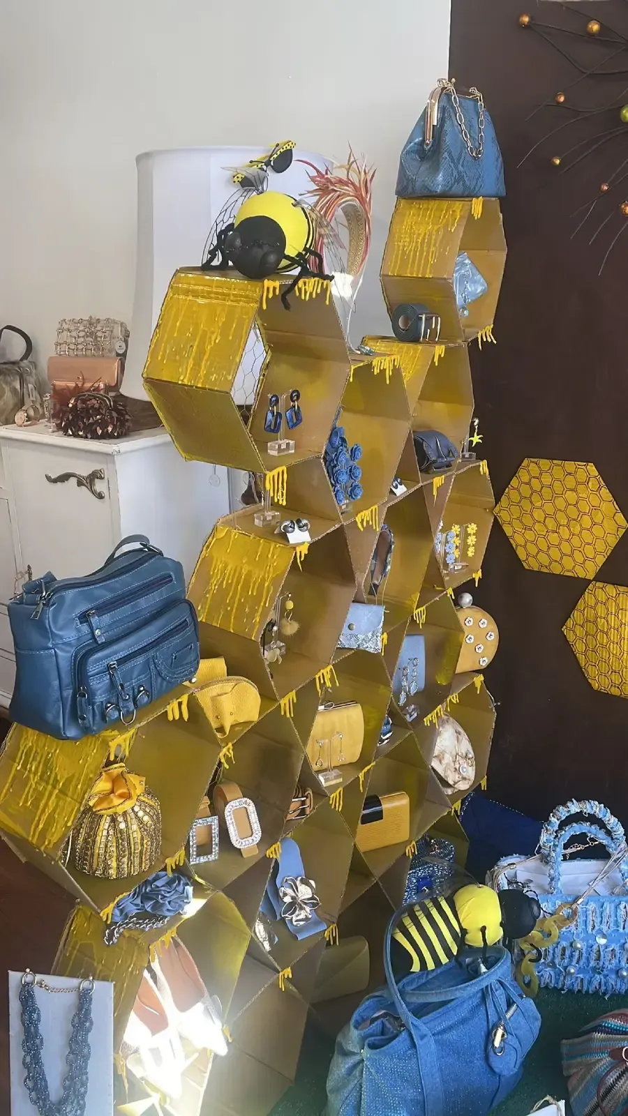 Exhibición en forma de panal llena de bolsos y joyas, principalmente de color amarillo y azul.