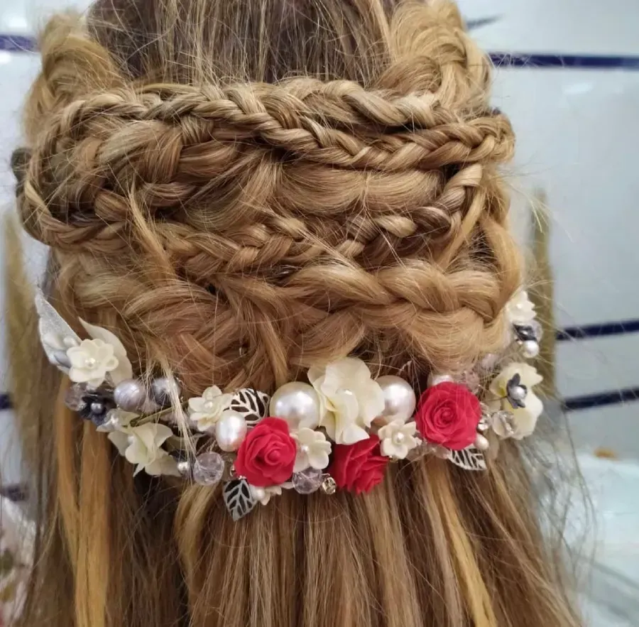 Recogido trenzado con tocado floral con rosas rojas y perlas.