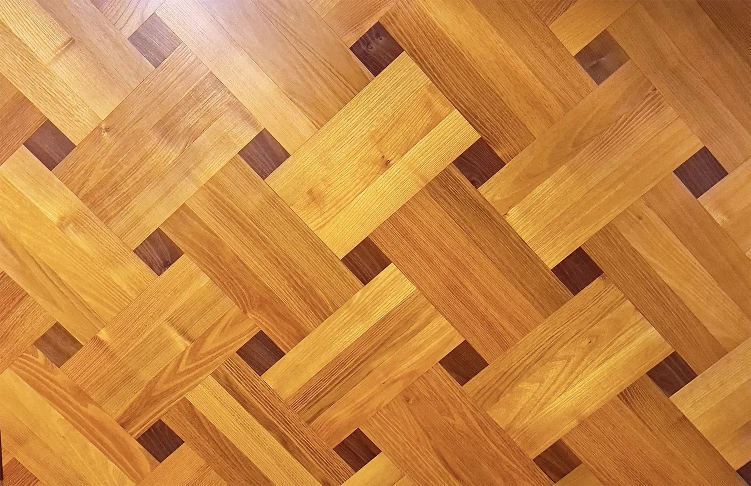 Eine Nahaufnahme eines Holzbodens mit Fischgrätenmuster