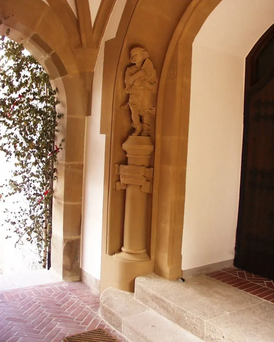 Ein steinerner Torbogen mit einer Männerstatue darauf