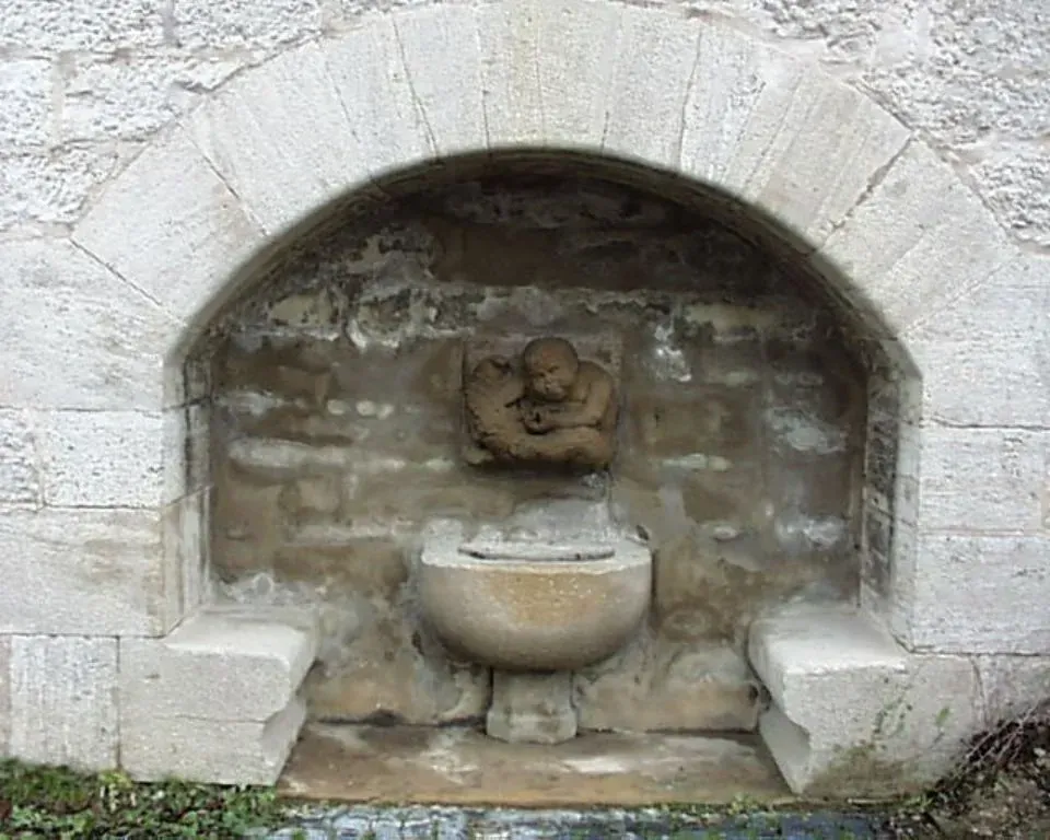 Ein Steinbrunnen mit einer Männerstatue darin