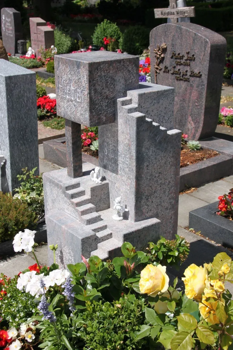 Ein Grab auf einem Friedhof mit Blumen und einem Kreuz