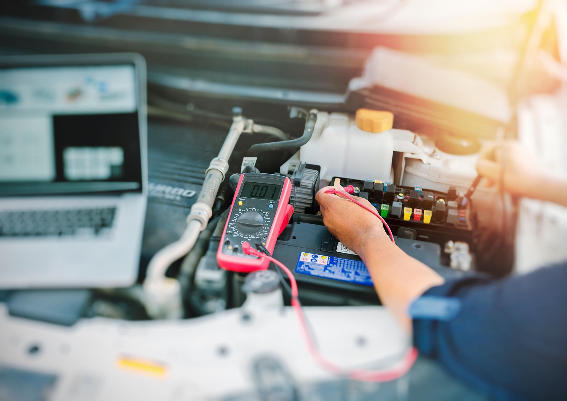 Persona utilizando un multímetro para diagnosticar el sistema eléctrico de un automóvil