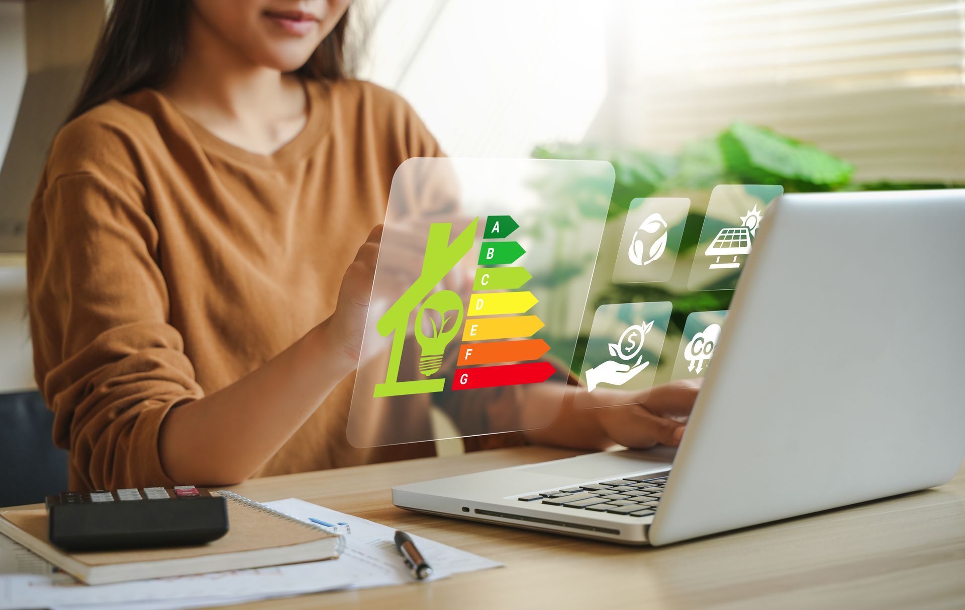 Femme utilisant un ordinateur portable avec un hologramme d'efficacité énergétique superposé.