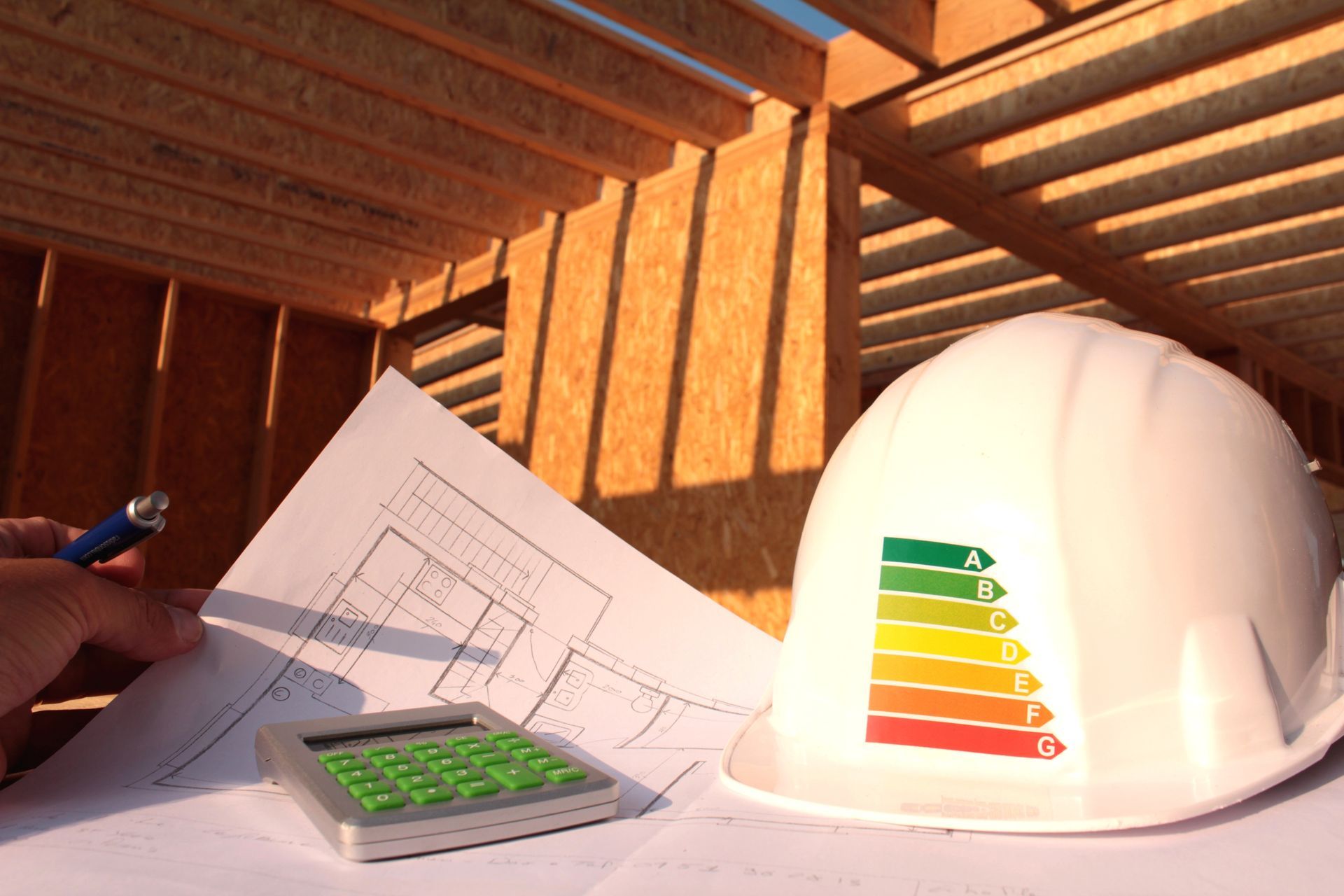 Chantier : plans, calculatrice, casque de chantier avec étiquette d'efficacité énergétique.