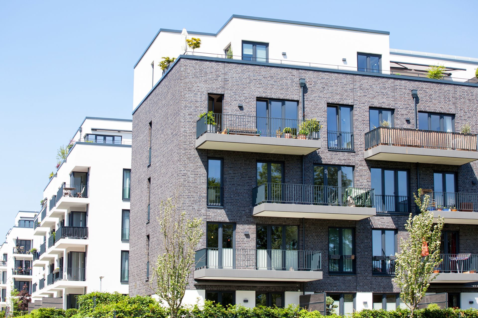 Immeubles d'appartements modernes en briques blanches sous un ciel d'un bleu éclatant.