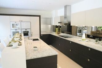 Una cocina con gabinetes en blanco y negro y encimeras de granito.