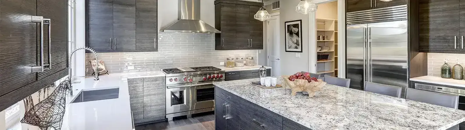 Una cocina con encimeras de granito y electrodomésticos de acero inoxidable.