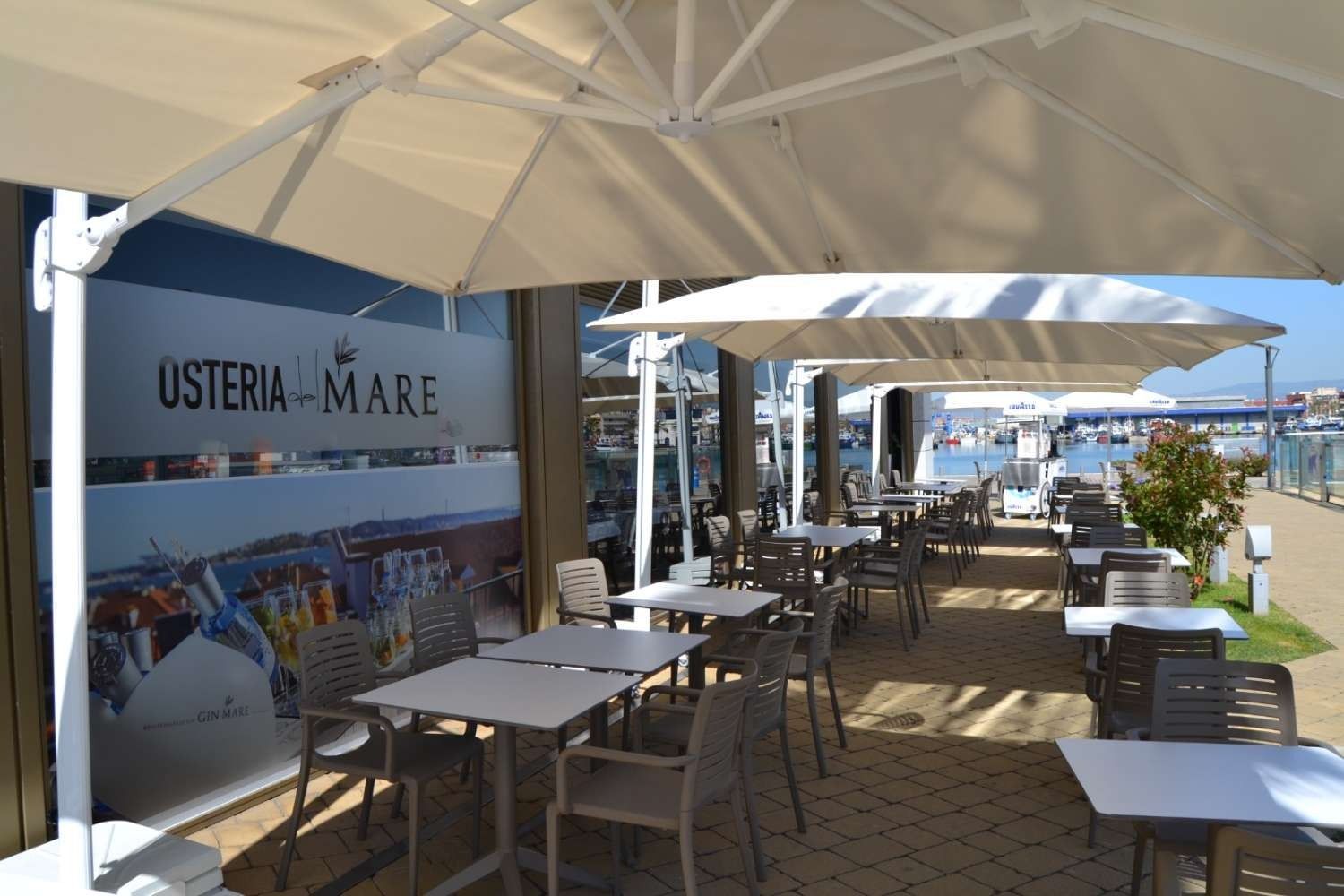 Un restaurante con mesas, sillas y sombrillas al aire libre.