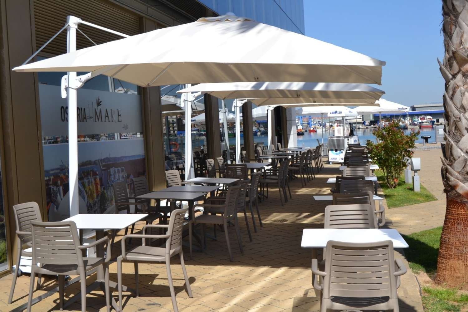 Un restaurante con mesas y sillas bajo sombrillas.