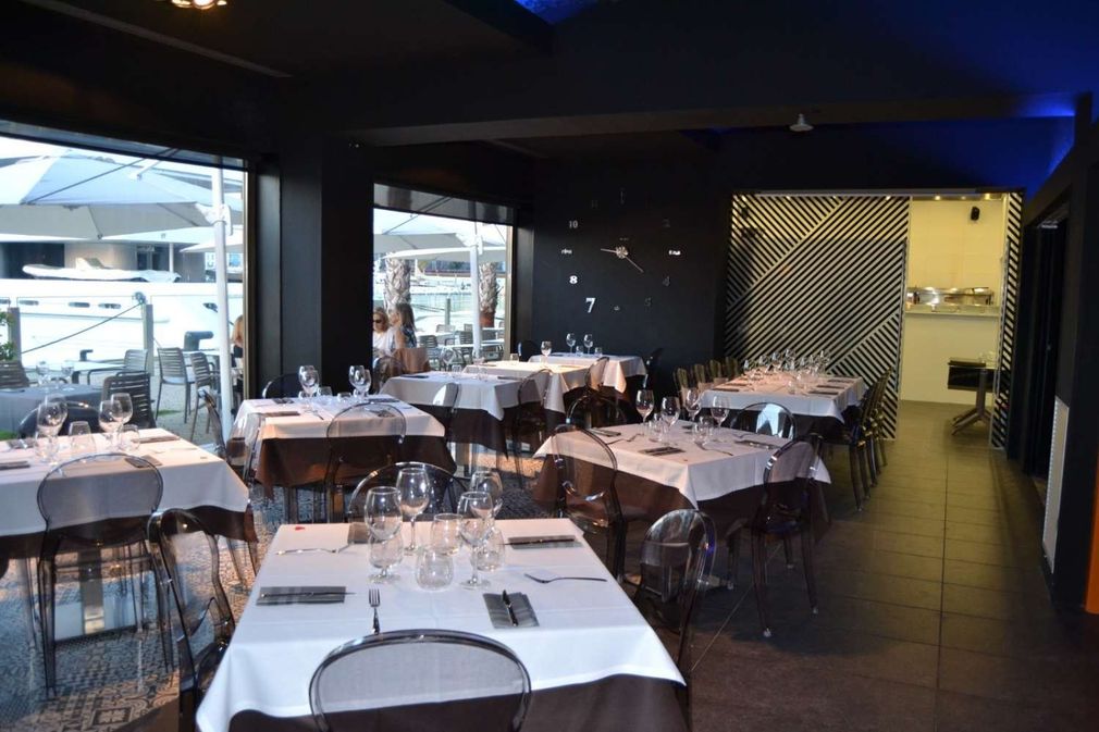 Un restaurante lleno de mesas y sillas y un techo azul.