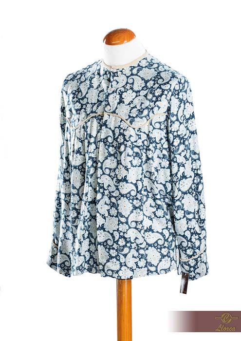 Una blusa de manga larga y corte holgado con estampado floral de cachemir azul y blanco, expuesta en un maniquí.
