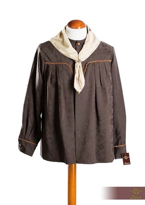 Una camisa marrón de manga larga con estampado y una bufanda beige al cuello se exhiben en un maniquí.