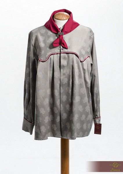 Camisa gris de manga larga con botones y un estampado sutil, cuello granate y detalle frontal a juego.