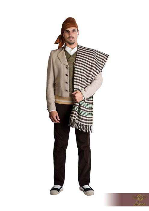 Una persona que viste ropa tradicional, que incluye una chaqueta color canela, pantalones oscuros, un chal a rayas y un tocado marrón.