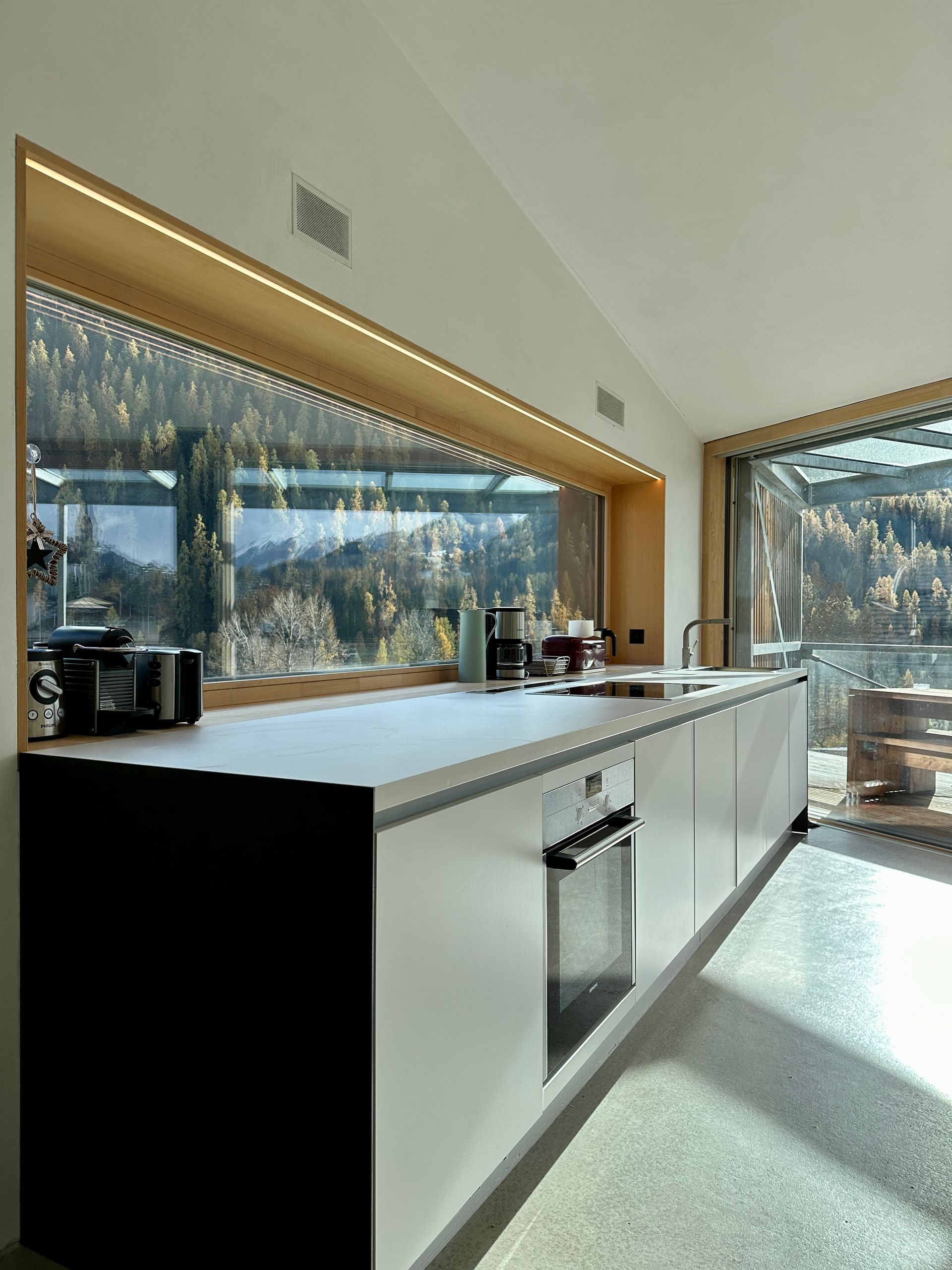 Bodentiefe Panoramafenster über der Küchenzeile im Ferienhaus Buna Saira mit Blick auf die umliegenden Berge