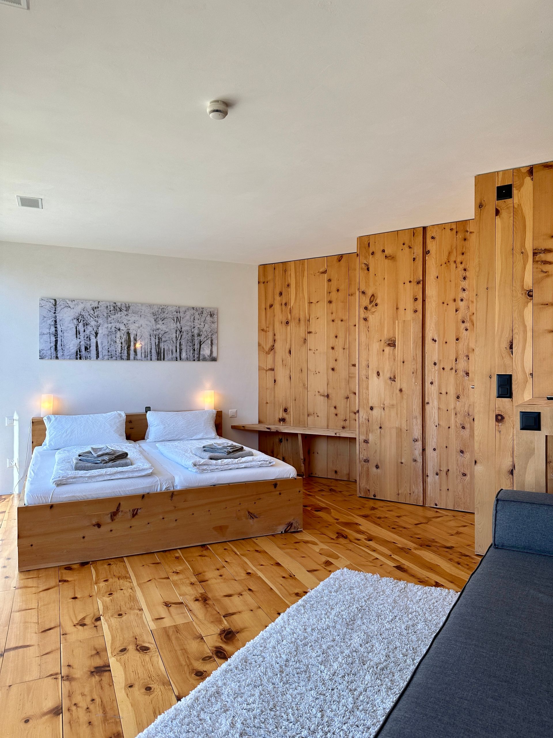 Modernes engadiner Schlafzimmer mit alpiner Holzverkleidung im Ferienhaus Buna Saira in Scuol