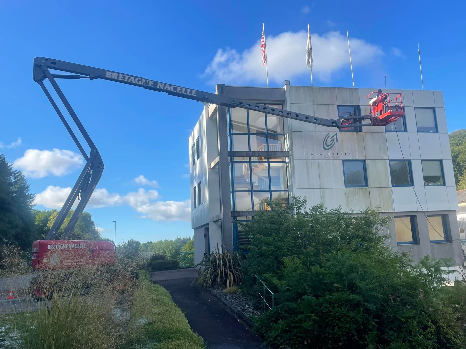 Un professionnel sur une nacelle nettoyant une façade