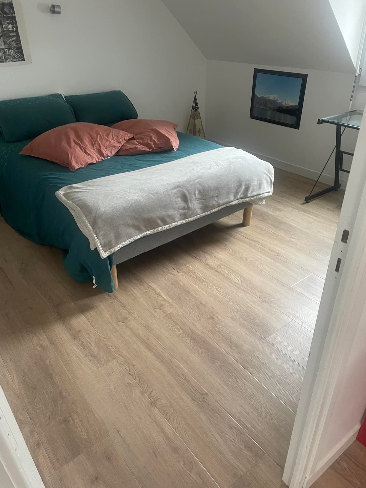 Une chambre avec un revêtement de sol en PVC qui imite le parquet