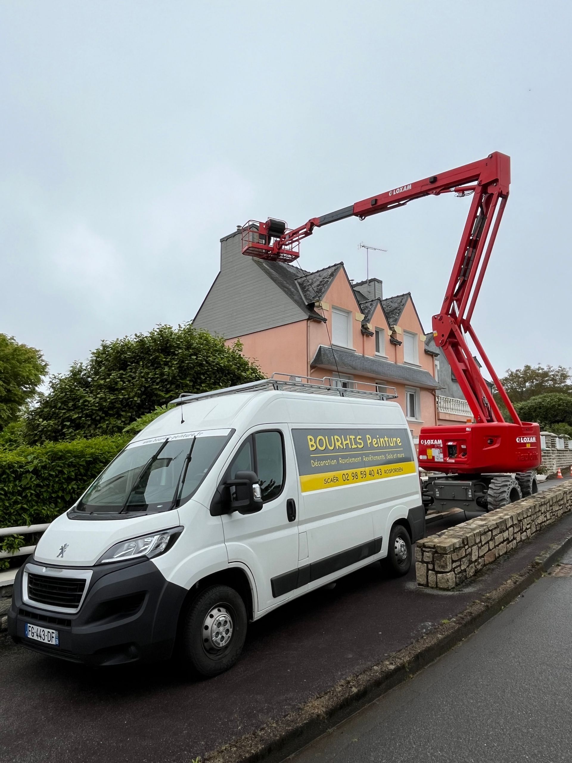 Une nacelle avec un ouvrier situé en hauteur pour nettoyer une façade
