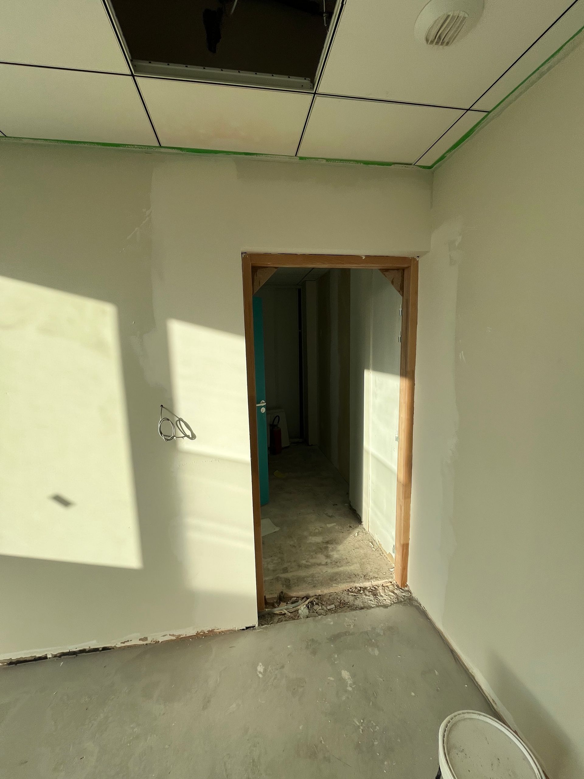 Un plaquiste qui applique de l'enduit sur un plafond