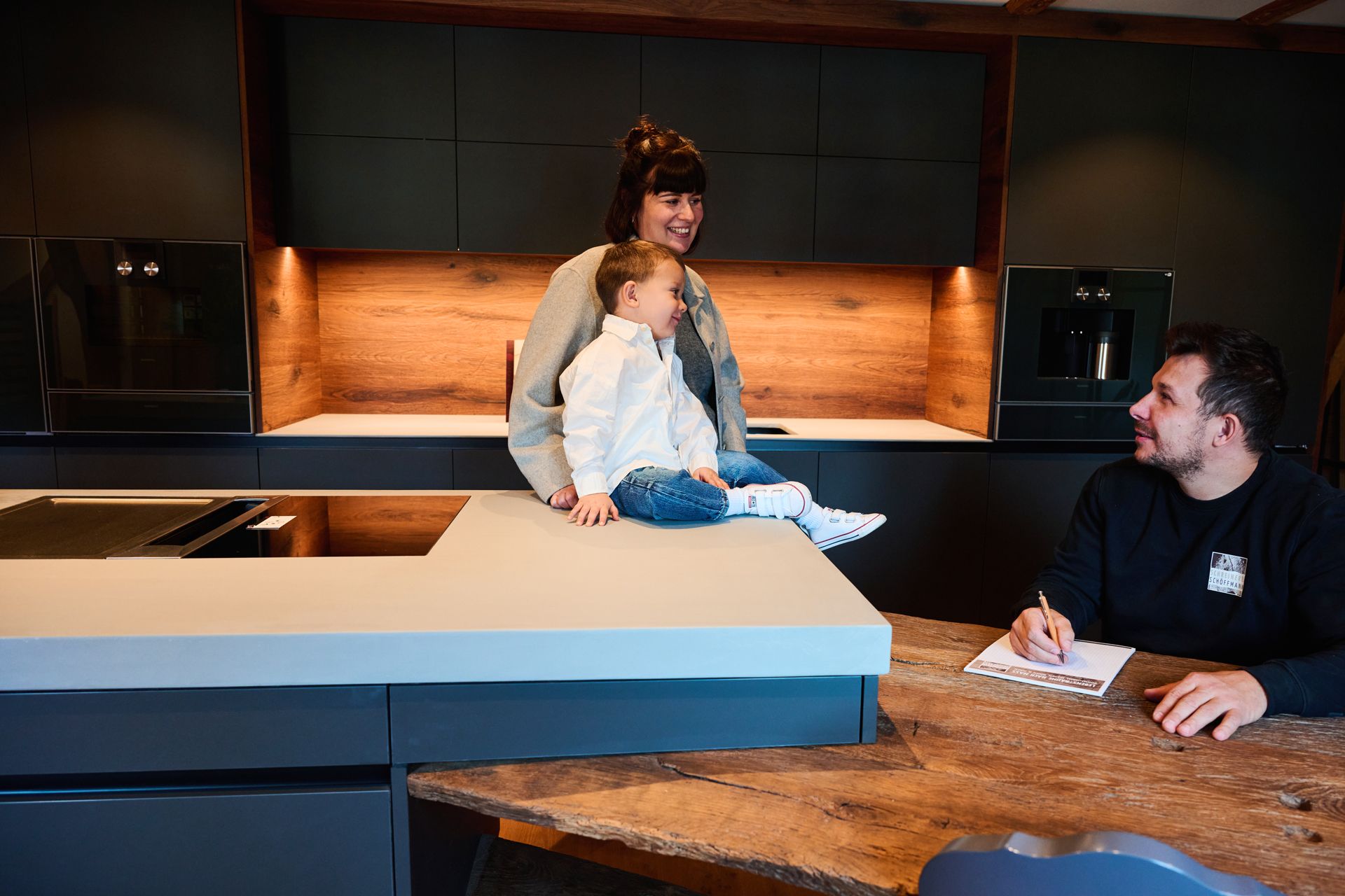 Familie in einer modernen Küche mit schwarz-matten Fronten