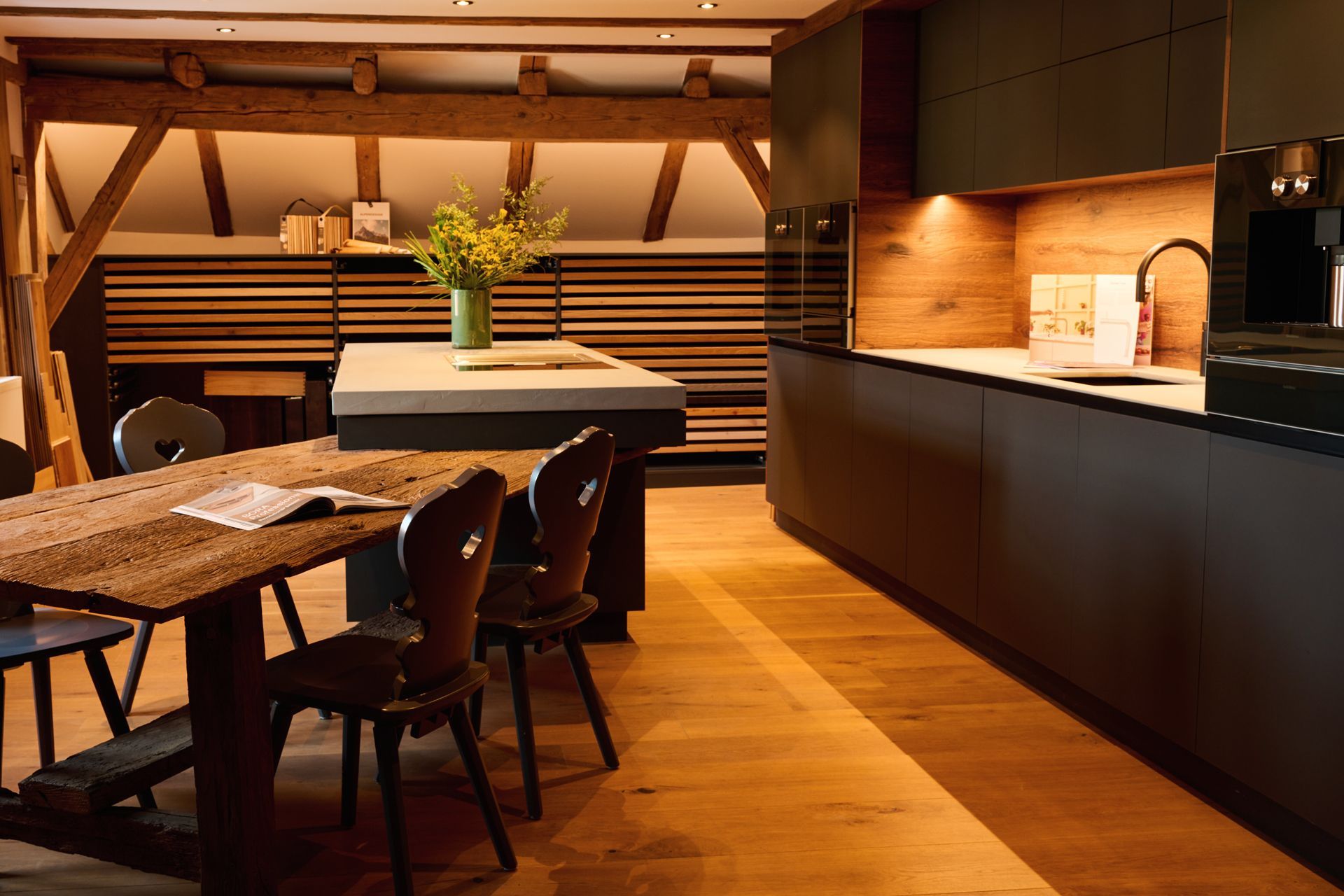 Minimalistische, grifflose Küche mit matten schwarzen Fronten und Holzarbeitsfläche