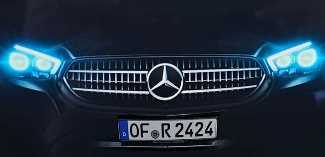 Zwei schwarze Mercedes-Benz-Autos stehen nebeneinander auf Kies.