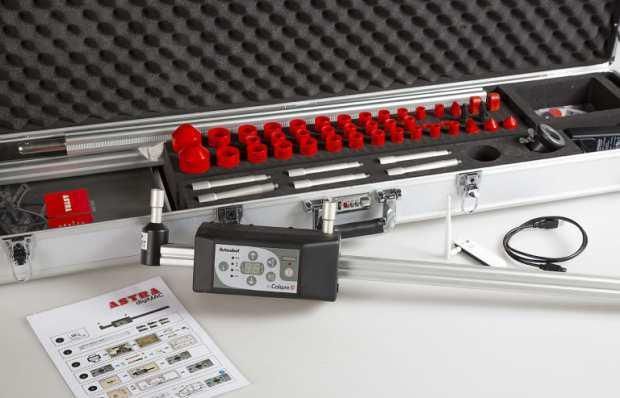 Un maletín lleno de herramientas y un control remoto sobre una mesa.