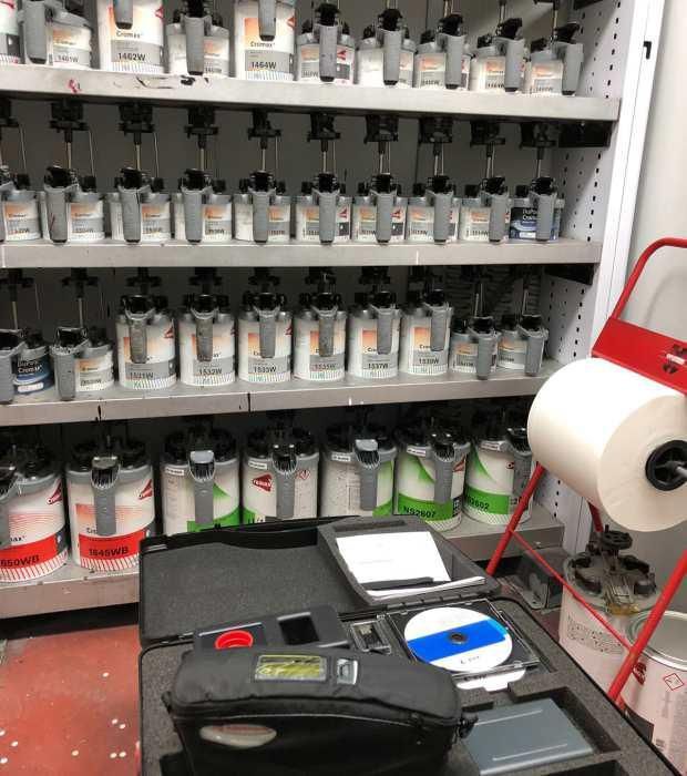 Un montón de botellas de pintura están alineadas en los estantes.