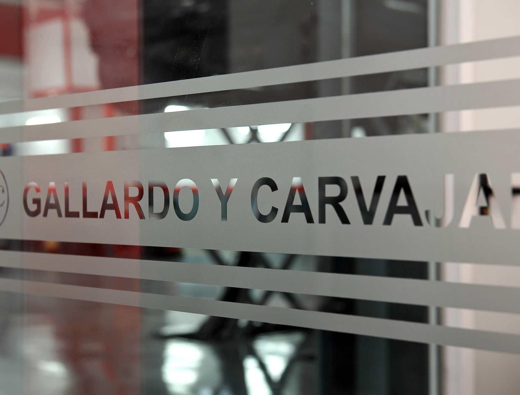 Un cartel en una puerta de vidrio que dice gallardo y carvajal.