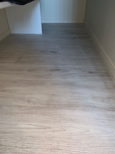 Couloir vide avec parquet clair et murs blancs
