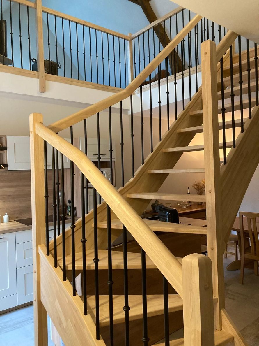 Escalier en bois avec rampes noires dans un intérieur lumineux