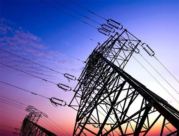 Una hilera de líneas eléctricas contra un cielo al atardecer