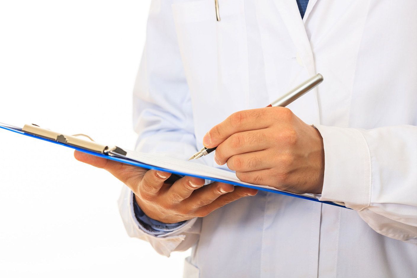 Un médico está escribiendo en un portapapeles con un bolígrafo.