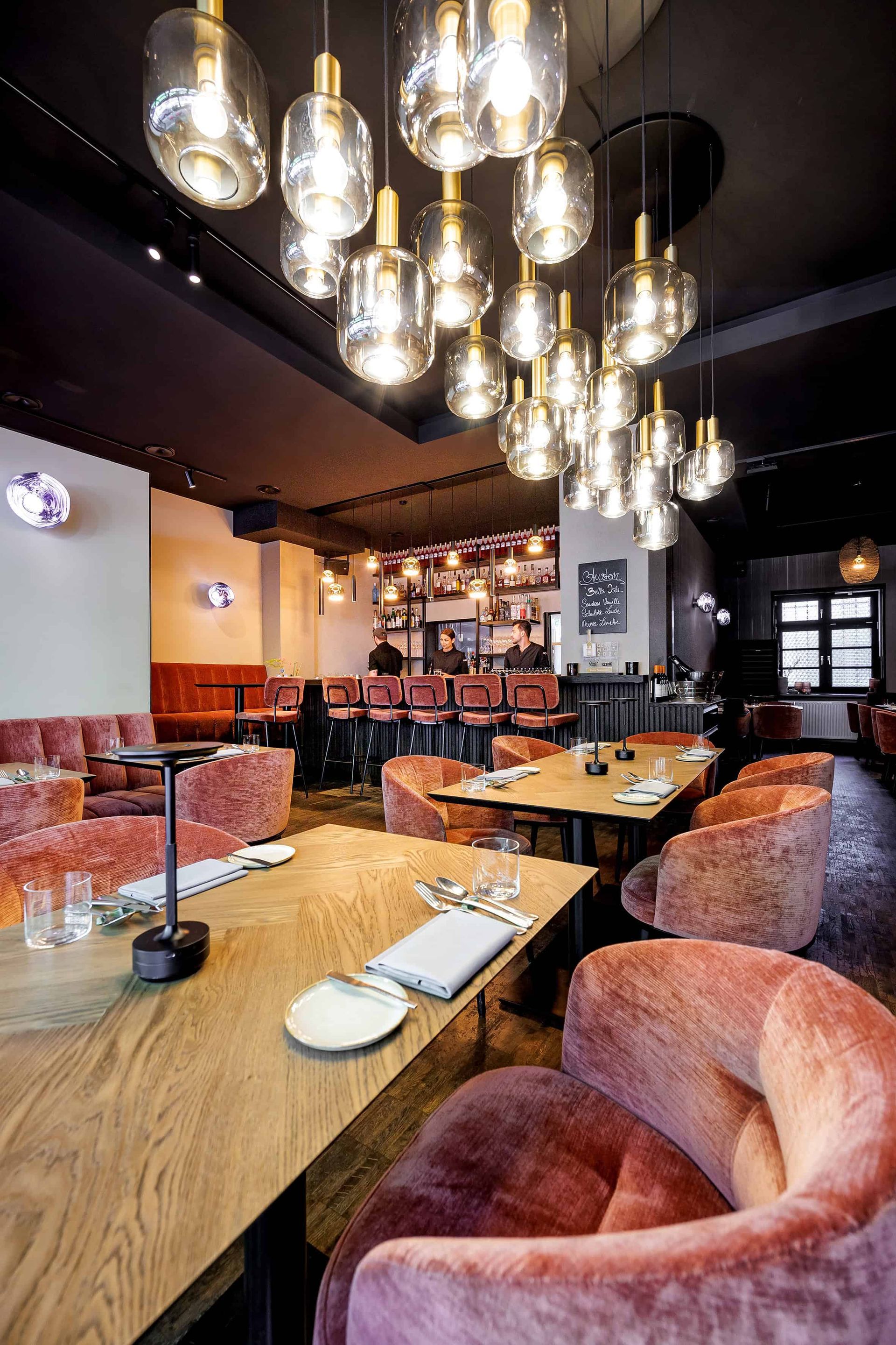 Ein Restaurant mit Tischen und Stühlen und vielen Lichtern, die von der Decke hängen.