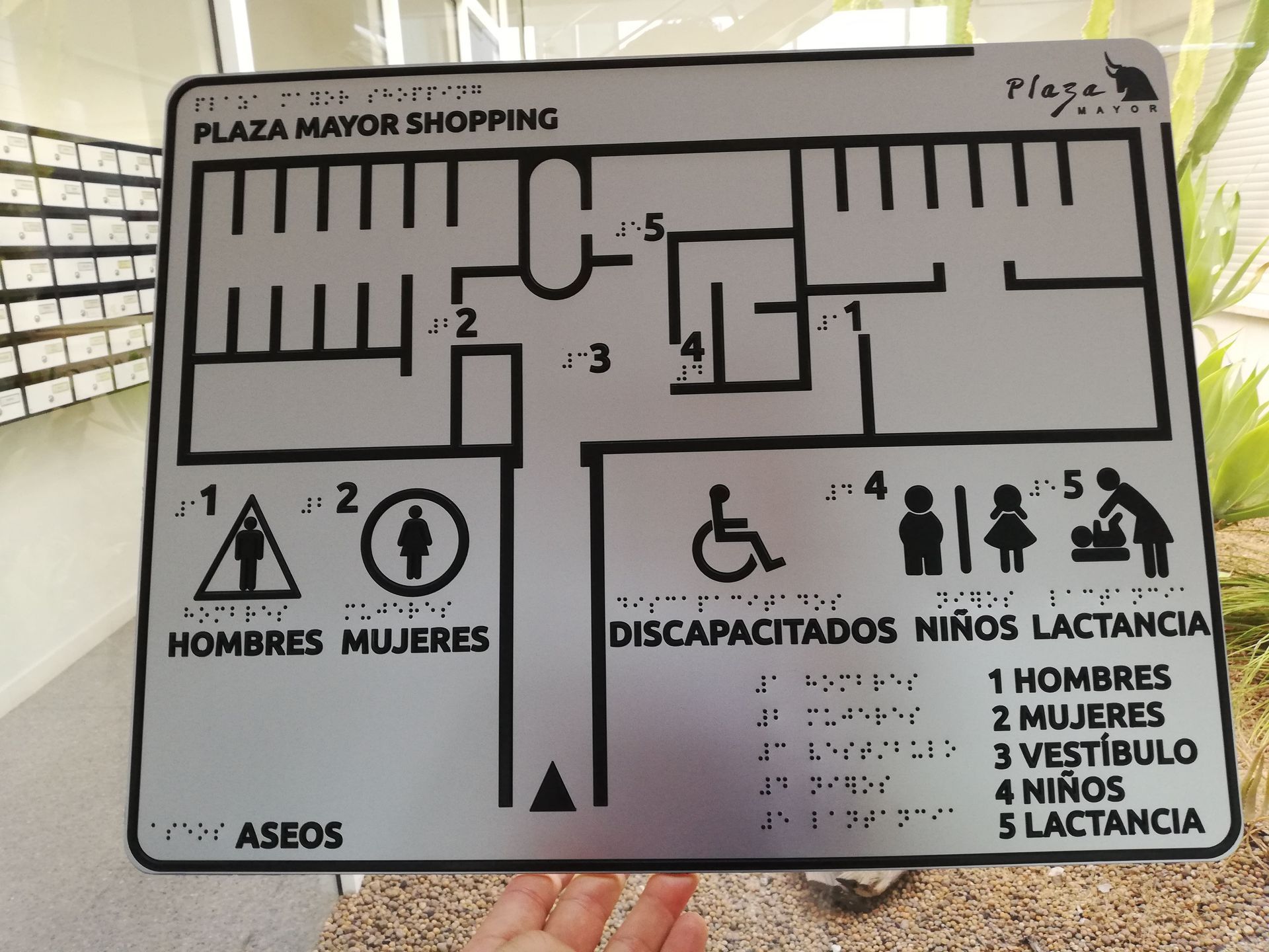 Una persona sostiene un mapa del centro comercial de la Plaza Mayor.