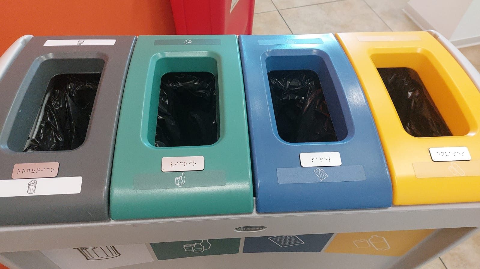 Un contenedor de reciclaje con cuatro contenedores de diferentes colores.