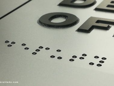 Un primer plano de un cartel con braille.